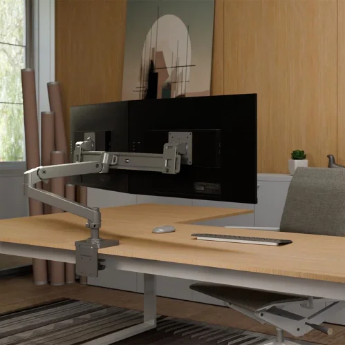 Uchwyt na monitor do biurka Ergotron LX Pro Desk Dual Direct w aranżacji stanowiska pracy. Ramię do monitora porządkuje przestrzeń i pozwala ustawić dwa ekrany nad blatem.