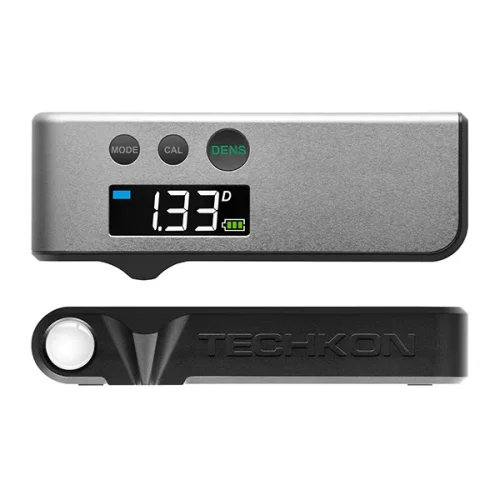 Widok densytometru TECHKON DENS z przodu i z boku. Urządzenie ma czytelny ekran, trzy przyciski sterujące i kompaktową obudowę, która ułatwia codzienną kontrolę jakości druku.