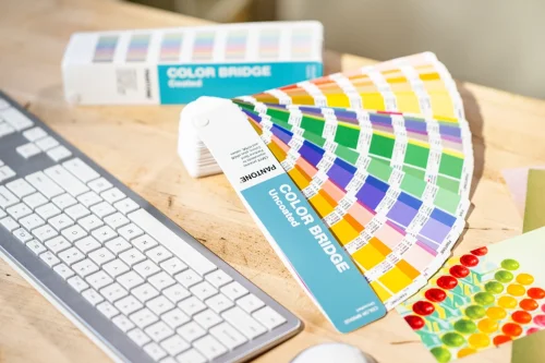 Pantone Color Bridge Uncoated przy stanowisku projektowym, wzornik Pantone do kontroli kolorów na papierze niepowlekanym i konwersji na CMYK.