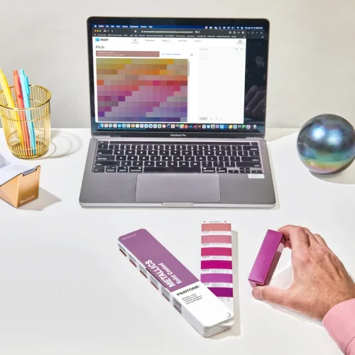 Pantone Metallics Coated Guide podczas pracy projektowej z Pantone Connect i fizycznymi próbkami kolorów metalicznych.