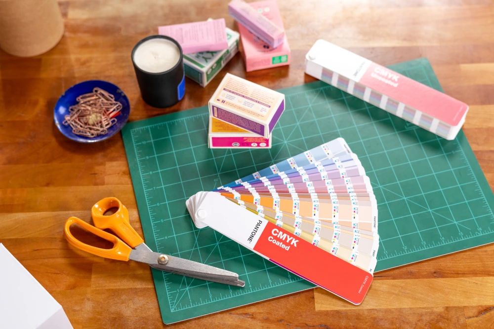 Pantone CMYK Guide Coated używany na stanowisku projektowym do wyboru kolorów procesowych